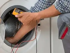 Washing machine repair technician testing a front-load washer with diagnostic tools in Denver, CO