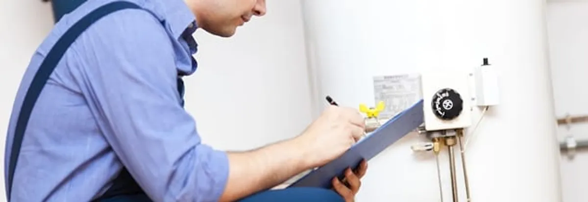 Water heater repair technician inspecting the unit and recording service notes in Denver, CO